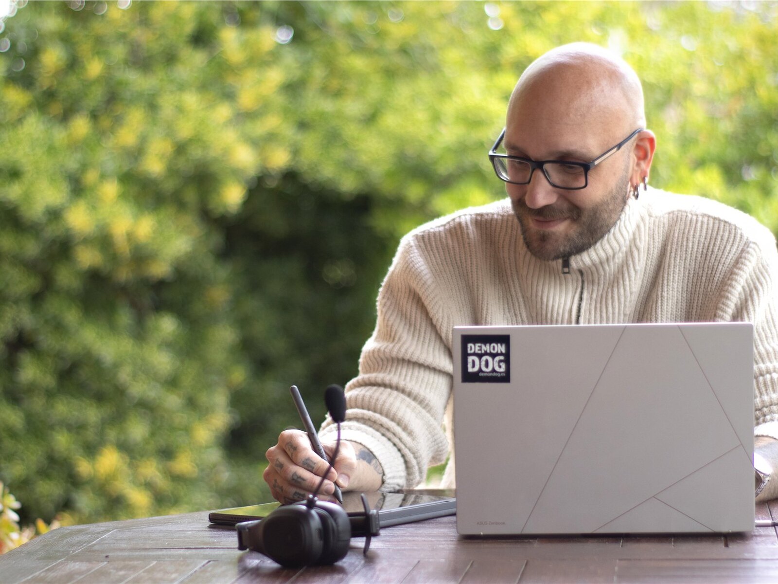 Björn working outdoors on a laptop, surrounded by trees.